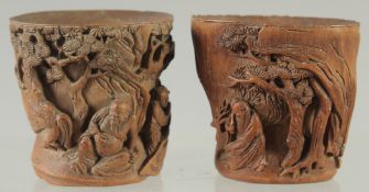 A SMALL PAIR OF CHINESE CARVED BAMBOO CUPS, relief carved with figures in a woodland scene, 5.5cm