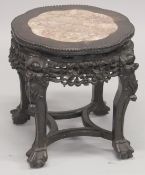 A GOOD CHINESE MARBLE INSET CARVED HARDWOOD STAND, with petal-form top and carved frieze, on four
