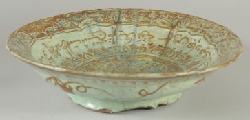 A PERSIAN KASHAN GLAZED POTTERY DISH, painted with peacock and calligraphy, (af), 29.5cm diameter.