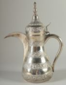 AN ISLAMIC SILVER EWER, with hinged cover and curving handle, curving spout, with alternating