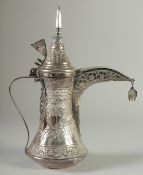 AN ISLAMIC SILVER EWER, with hinged cover and strapwork handle, curving spout, all with embossed and