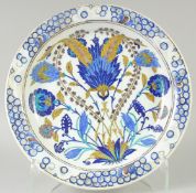 AN OTTOMAN TURKISH IZNIK GLAZED POTTERY PLATE, with central floral spray, 33cm diameter.