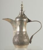 A 19TH CENTURY ARABIC ENGRAVED SILVER COFFEE POT, with hinged lid and strapwork handle, curving