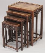 A GOOD CHINESE HARDWOOD NEST OF TABLES, comprising four graduating tables with carved frieze and
