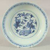 A CHINESE BLUE AND WHITE PORCELAIN DISH, decorated with phoenix amongst stylised clouds, 25cm