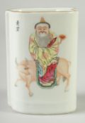 A SMALL CHINESE FAMILLE ROSE PORCELAIN BRUSH POT, painted with a figure seated upon a bull, the