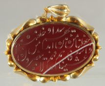 A FINE ISLAMIC CALLIGRAPHIC RED STONE SEAL inset within a gilt metal pendant, stamped to the
