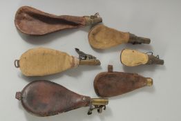 SIX VARIOUS LEATHER MOUNTED POWDER FLASKS.