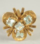 AN 18CT GOLD AQUAMARINE SET CLOVER SHAPED RING.