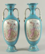 A PAIR OF BLUE SEVRES DESIGN TWO HANDLED VASES with panels of cupids.