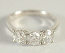 A PLATINUM AND DIAMOND THREE STONE RING.