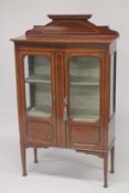 AN EDWARDIAN INLAID MAHOGANY BOW FRONT TWO DOOR DISPLAY CABINET with a gallery back, two fixed