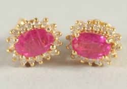 A PAIR OF 18CT YELLOW GOLD, RUBY AND DIAMOND CLUSTER STUD EARRINGS.