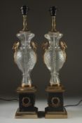 A PAIR OF BRONZE AND CUT GLASS LAMPS on square bases. 25ins high.