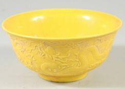 A CHINESE YELLOW GROUND CIRCULAR BOWL with dragons in relief. Mark in blue. 6ins diameter.