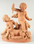 A GOOD LATE 19TH CENTURY TERRA COTTA GROUP, depicting two children tormenting a dog, holding a