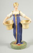 A RARE RUSSIAN PORCELAIN FIGURE OF A LADY, POSSIBLY ST. PETERSBURG, in a blue dress carrying two