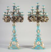 A GOOD PAIR OF SEVRES STYLE PORCELAIN AND ORMOLU CANDELABRA, blue ground edged in gilt. 27ins high.