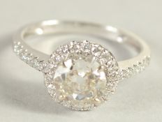 A SUPERB 18CT WHITE GOLD, 1 CARAT CENTRAL STONE, HALF CLUSTER RING.