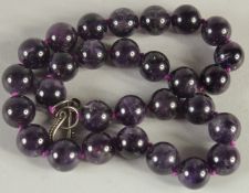 AN AMETHYST BEAD NECKLACE. 18ins long.