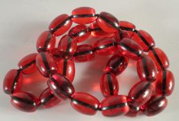 A STRING OF THIRTY TWO LARGE AMBER TYPE BEADS. 30ins long.