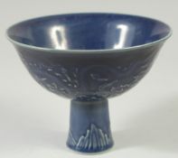 A CHINESE BLUE GROUND CIRCULAR STEM CUP with dragons in relief. Mark in blue.