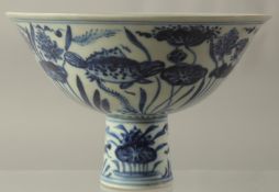 A CHINESE PORCELAIN BLUE AND WHITE STEM CUP painted with fish. 6.5ins high.