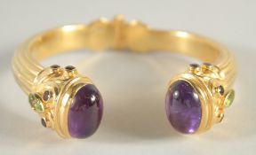 A SILVER GILT, AMETHSTY AND PERIDOT SPRUNG TORQUE BANGLE.