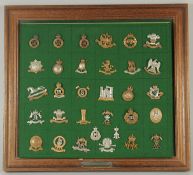 A FRAMED COLLECTION OF 32 BADGES 