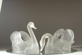 A VERY GOOD PAIR OF LALIQUE FROSTED GLASS SWANS on mirrored plateau stand. 23ins x 15ins Etched