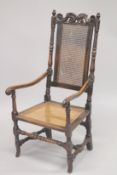 AN 18TH CENTURY OAK ARM CHAIR with cane work back and seat.