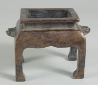 A CHINESE BRONZE RECTANGULAR CENSER on legs. 5ins high.