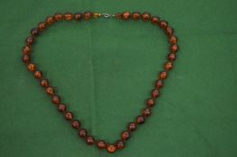 AN AMBER GRADUATED BEAD NECKLACE.