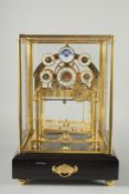 A GOOD MOON PHASE BRASS CONGREAVE CLOCK in a glass dome. 12ins high.