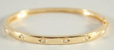 AN 18CT YELLOW GOLD AND DIAMOND HINGED BANGLE.