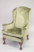 A GEORGIAN MANNER MAHOGANY FRAMED WING ARM CHAIR on cabriole legs with claw and ball feet.