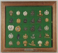 A FRAMED COLLECTION OF 30 BADGES 