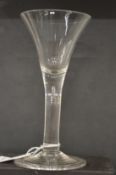AN 18TH CENTURY ENGLISH WINE GLASS with tapering bowl.