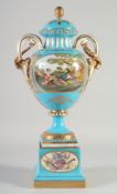 A SEVRES STYLE PORCELAIN TWO HANDLED URN COVER AND STAND blue ground edged in gilt with panels of