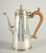 A PLAIN GEORGE II SILVER TAPERING COFFEE POT AND COVER with wooden handle. London 1737. Maker,