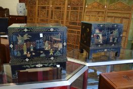 A pair of Chinese black lacquer and chinoiserie decorated low two door cabinets.