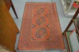 A Persian rug, red ground with three large motifs 167cm x 100cm.