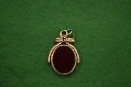 A gold and carnelian swivel fob seal.
