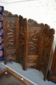 A good Chinese carved hardwood four panel folding dressing screen.