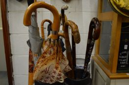 Various walking sticks and umbrellas.