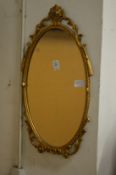 A gilt framed mirror and a gilt plaster cherub wall bracket.