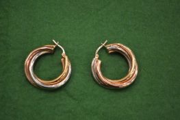A pair of gold triple hoop earrings.