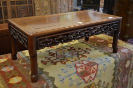A Chinese hardwood low table with carved and pierced frieze.