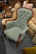 A Victorian mahogany framed button upholstered armchair.