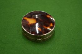 A silver and tortoiseshell circular patch box.